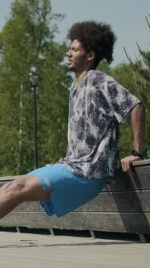 Young Man Doing Bench Dips during Outdoor Street Workout