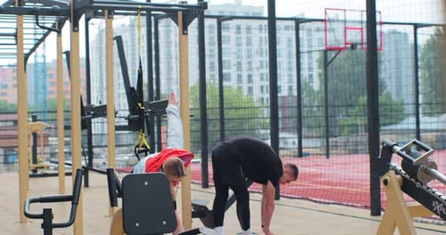 Man and Woman Stretching at Outdoor Urban Gym