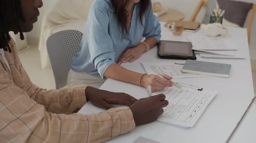 UX Designers Discussing Project Tasks at Table with Gadgets
