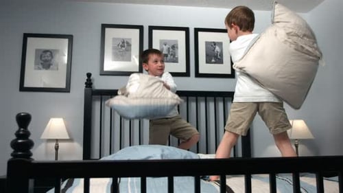 Boys Having a Pillow Fight on Bed Indoors