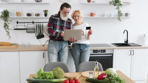 Senior Couple Shopping Online with Laptop at Home