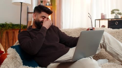 Man Relaxing on Couch Using Laptop at Home