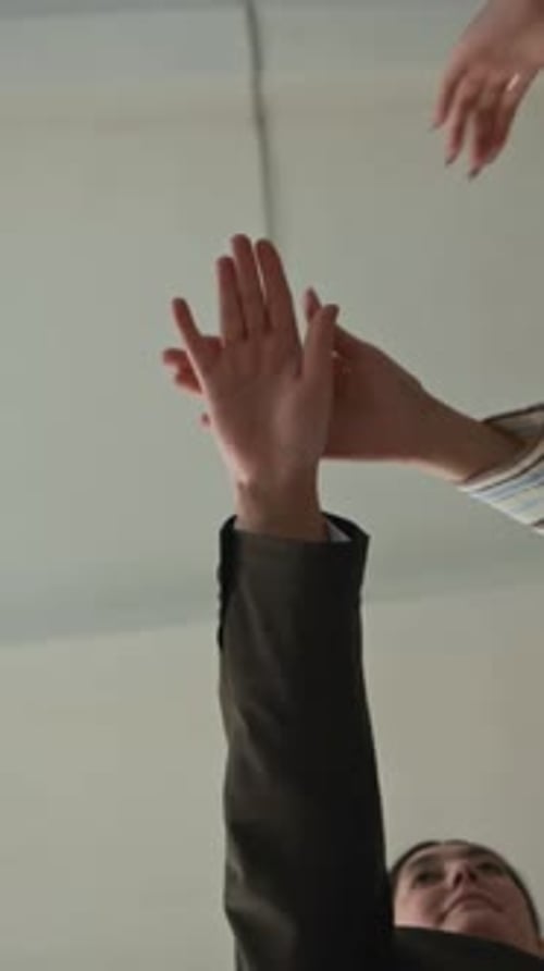 Vertical of Teacher Stacking Hands Together with Students in Circle