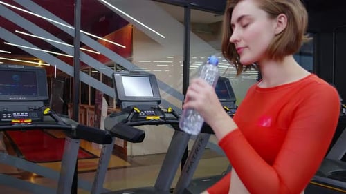 Woman Drinks Water After Gym Workout