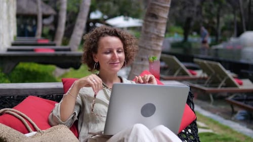 Woman Using Laptop at Tropical Resort