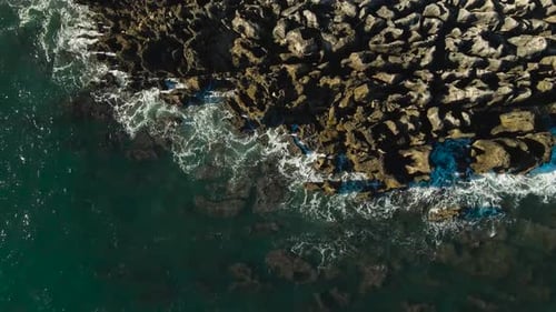 Aerial View of Waves Crashing on Rocky Shoreline