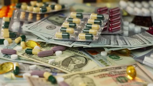 Background Video of Money and Antibiotic Pill Boxes