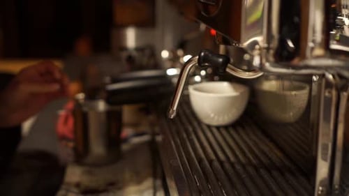 Female barista cleaning and frothing milk coffee machine - CLOSE UP