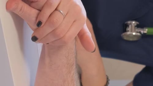 Doctor holds patient's wrist during examination