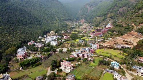 A beautiful aerial view of the small town of Dakshinkali, Nepal surrounded by fields and the foothil