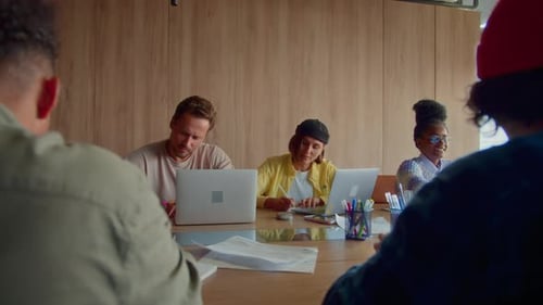 Group of Professionals Works on Laptops Sitting at Desk