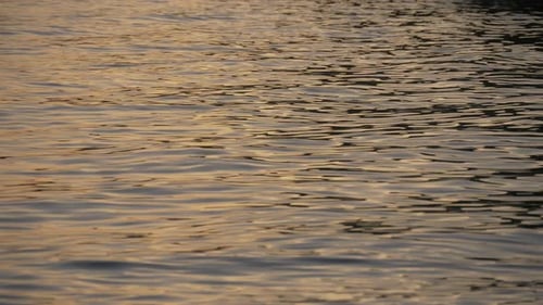 Reflexionen eines Sonnenuntergangs auf den Wellen eines Sees