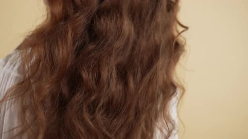 Woman with Red Curly Hair Fixes a Strand
