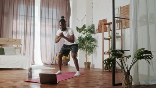 Young Adult Does Squats at Home