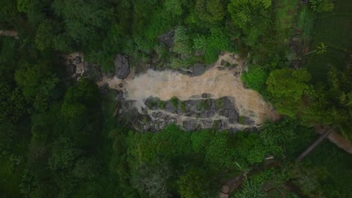 Top Down Descending Shot of Large Mass of Water Falling Down on Cascades on Rocks Surrounded By