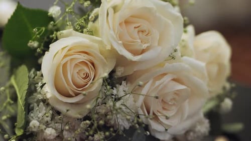 Closeup of beautiful bouquet of white roses with green foliage designed for a wedding