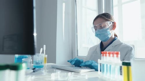 Woman Scientist Typing at Lab Bench