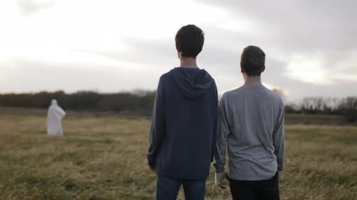 Two Young Adults Standing in Grassy Rural Field