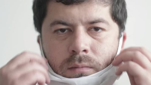 Man Puts On a Protective Face Mask