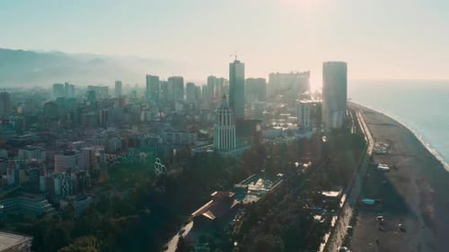 Aerial Drone View of Modern Coastal City with Skyscrapers Highrise Buildings and Tower at Sunset