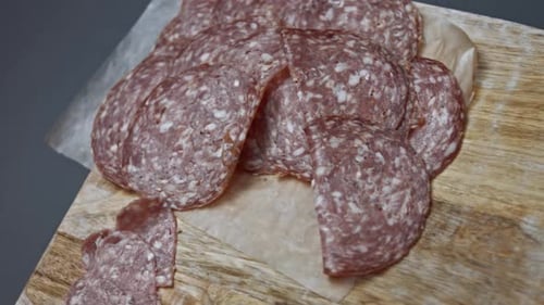 Fresh Italian Sliced Salami Sausage on a Wooden Cutting Board Heart Shapes of Milano Salami Sausage