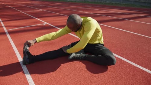 Adult Man Stretches on Outdoor Running Track