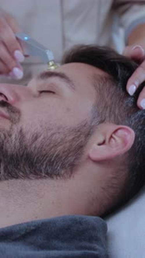 Man Getting Facial Treatment with Modern Beauty Tool