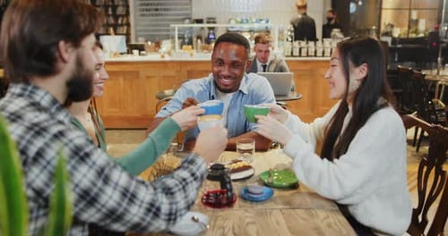 Friends Company Multiethnic Happy Friends Meeting in Cafeteria Drinking Coffee and Toasting Cups