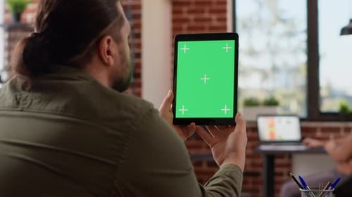 Office Worker Analyzing Greenscreen Template on Digital Tablet