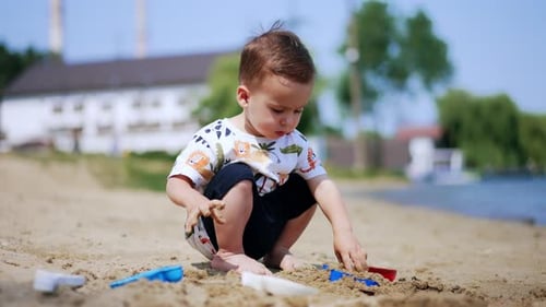 Child Playing with Sand Toys on Beach