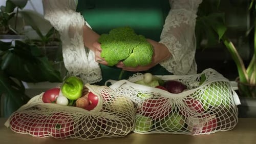 Desempacar la bolsa de la compra después de comprar, poner verduras sobre la mesa en la cocina