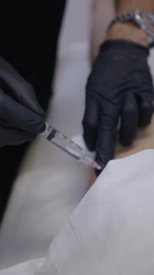 Doctor Injecting a Needle Into a Mesotherapy Patients Leg