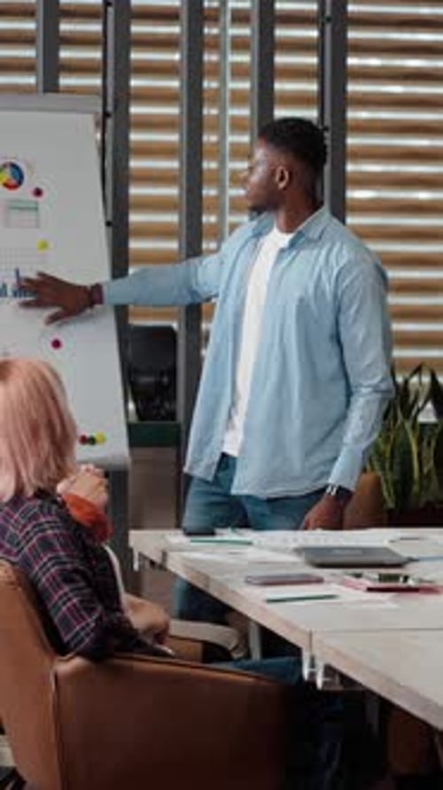 African Male Sales Manager in Casual Denim Presenting His Quarter Report to His Business Partners
