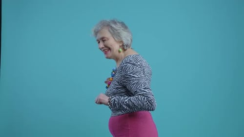 Funny grandmother old woman posing on colored background.