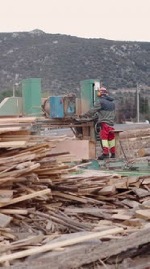 Entre un montón de maderas, un hombre irreconocible trabajando
