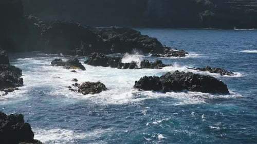 Eine große Welle des Atlantiks bricht an einer Felsenküste an einem sonnigen Tag während eines Sturms in der