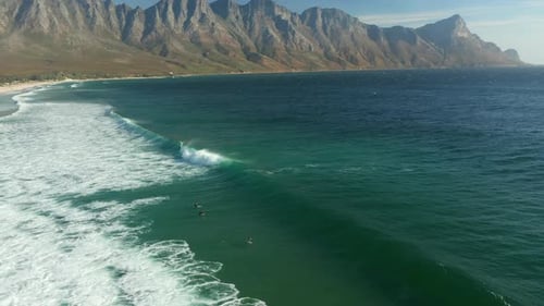 Aerial View Of Surfers And Foamy Ocean At Kogel Bay Beach, Cape Town, South Africa - drone shot