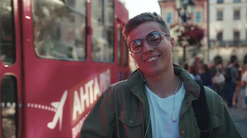 Close Up Face Happy Young Man with Glasses Use Phone Listen Music in Headphone Smile Background Tram