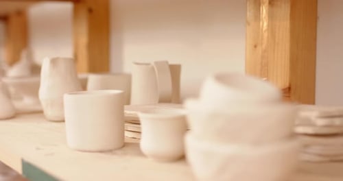 Ceramic products lying on shelf in pottery studio