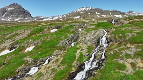 River Flows Through Mountains in Summer Season Waterfalls on Hills in Iceland