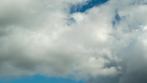 Time lapse of nomadic clouds on blue sky.