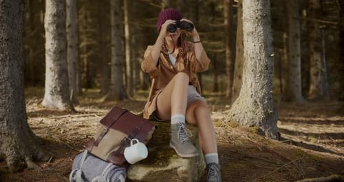 Female Explorer Looking Through Binoculars in Forest