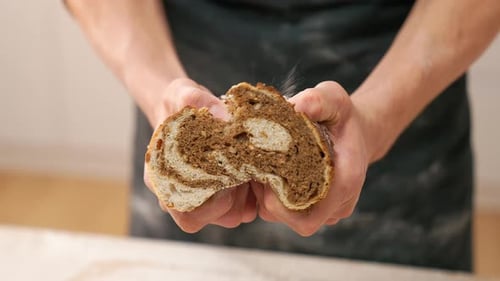 Baker Breaks Open Freshly Baked Delicious Bread