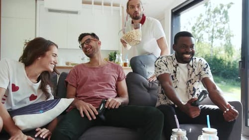 Friends Laughing and Playing Video Games at Home