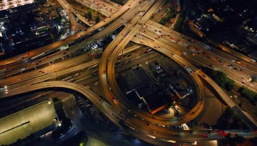 Boucles, autoroutes et autoroutes avec de nombreuses voitures en mouvement. Vue de dessus de l'échangeur de Los Angeles