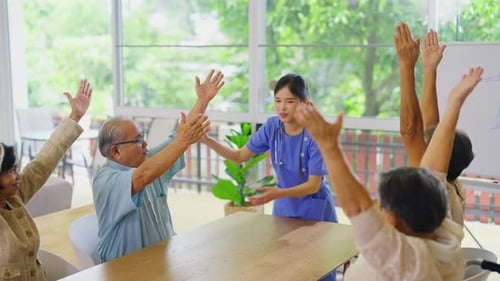 Young Asian nurse stand in front of group of senior or elderly people to show as example exercise