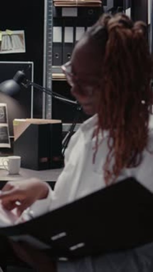 Young Adult Reviews Documents in Office Setting