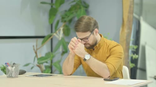 Man Thinking at Desk in Modern Workplace
