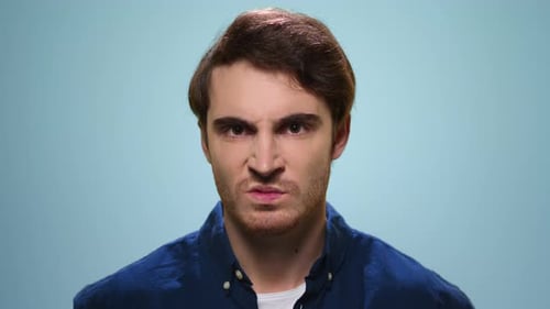 Angry Man Looking at Camera. Closeup Displeased Guy Standing in Studio. Portrait