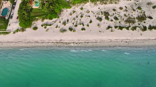 Aerial View of Sea Waves Crashing on Sandy Beach in Summer